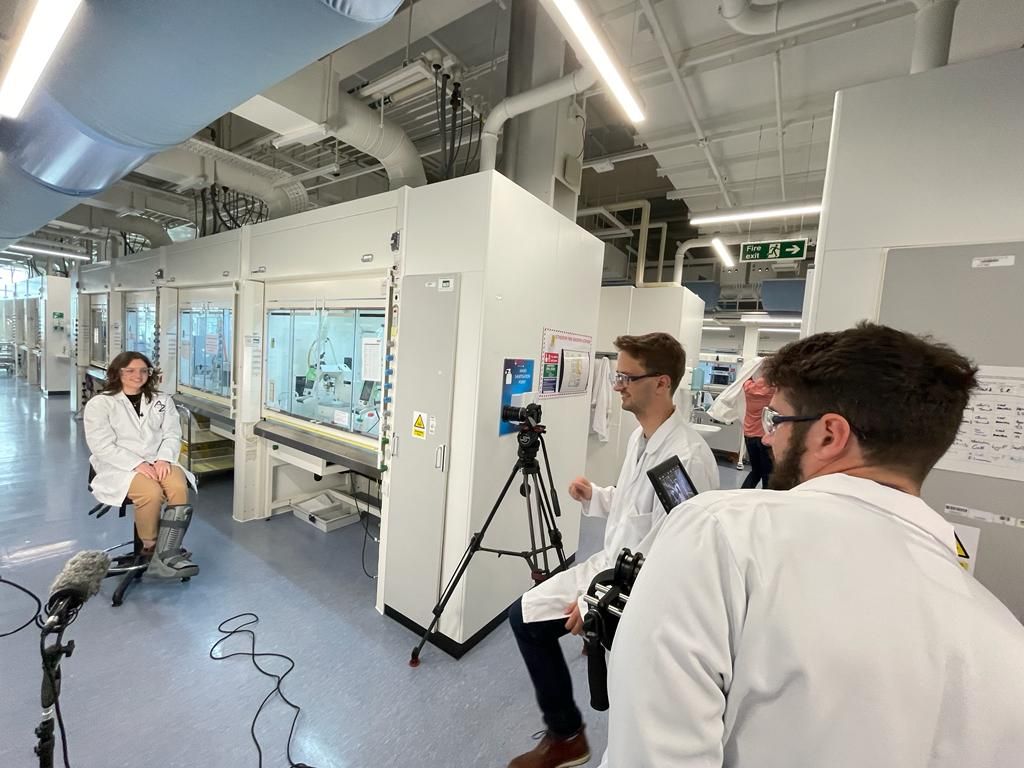 Film crew filming woman in laboratory