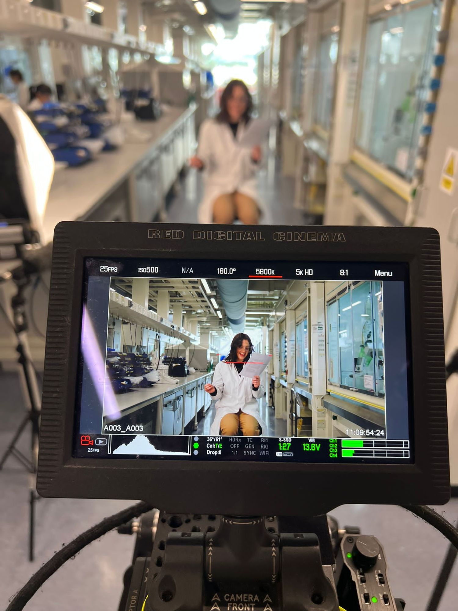 Camera filming a woman in a laboratory