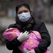 A woman carrying her child to be vaccinated (Credit: EPA) thumbnail