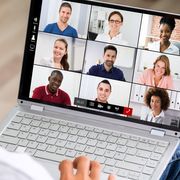 File image of a worker looking at faces of several colleagues on screen thumbnail
