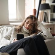 File image of a bored woman looking at her phone thumbnail