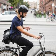 Man checks his phone while riding a bike thumbnail