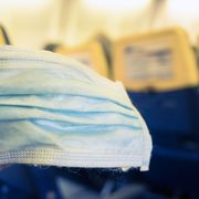 Plane passenger holding a mask thumbnail