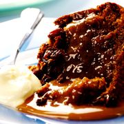 Slice of sticky toffee pudding served with cream thumbnail