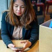 A woman who has resigned sits looking at her phone thumbnail