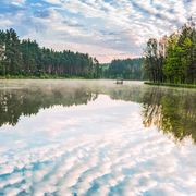 Clouds reflected on water in a peaceful natural setting outside Kyiv, Ukraine thumbnail