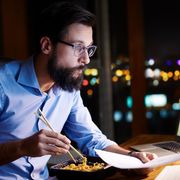 Man eating noodles at his desk thumbnail