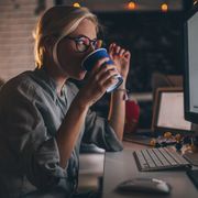 Woman drinking coffee as she works thumbnail