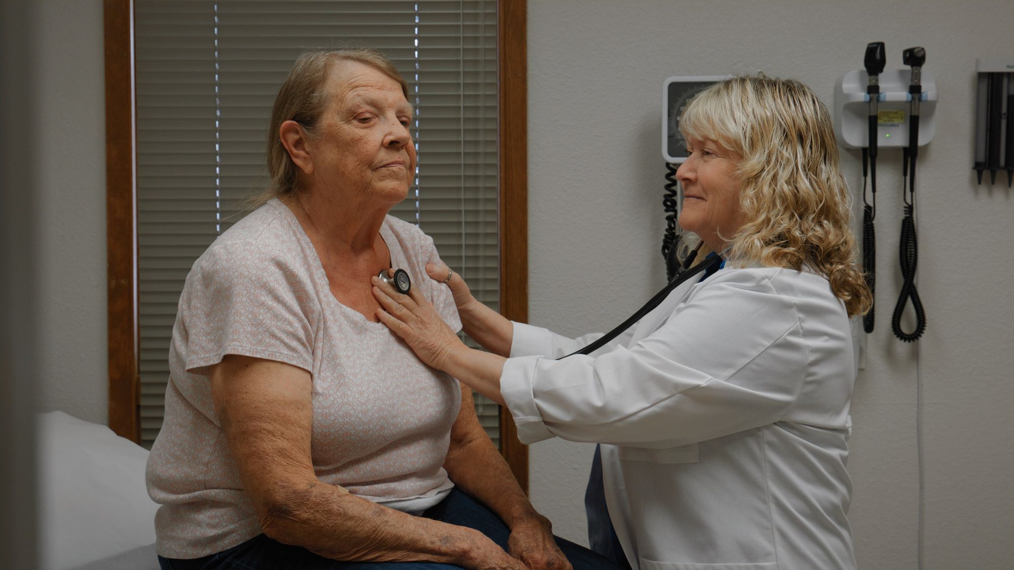 Doctor taking woman's heartbeat