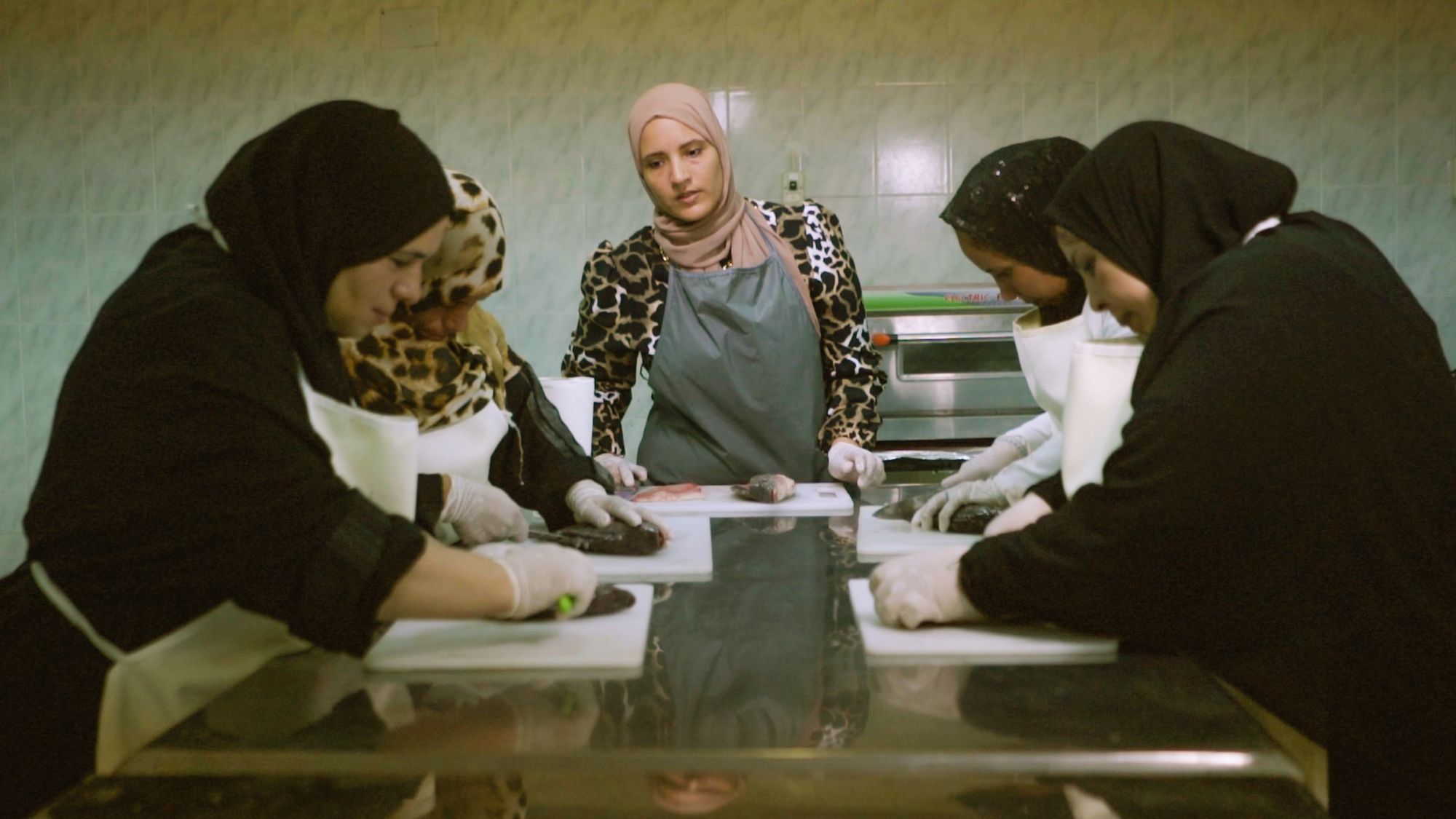 A group of women are cutting fish