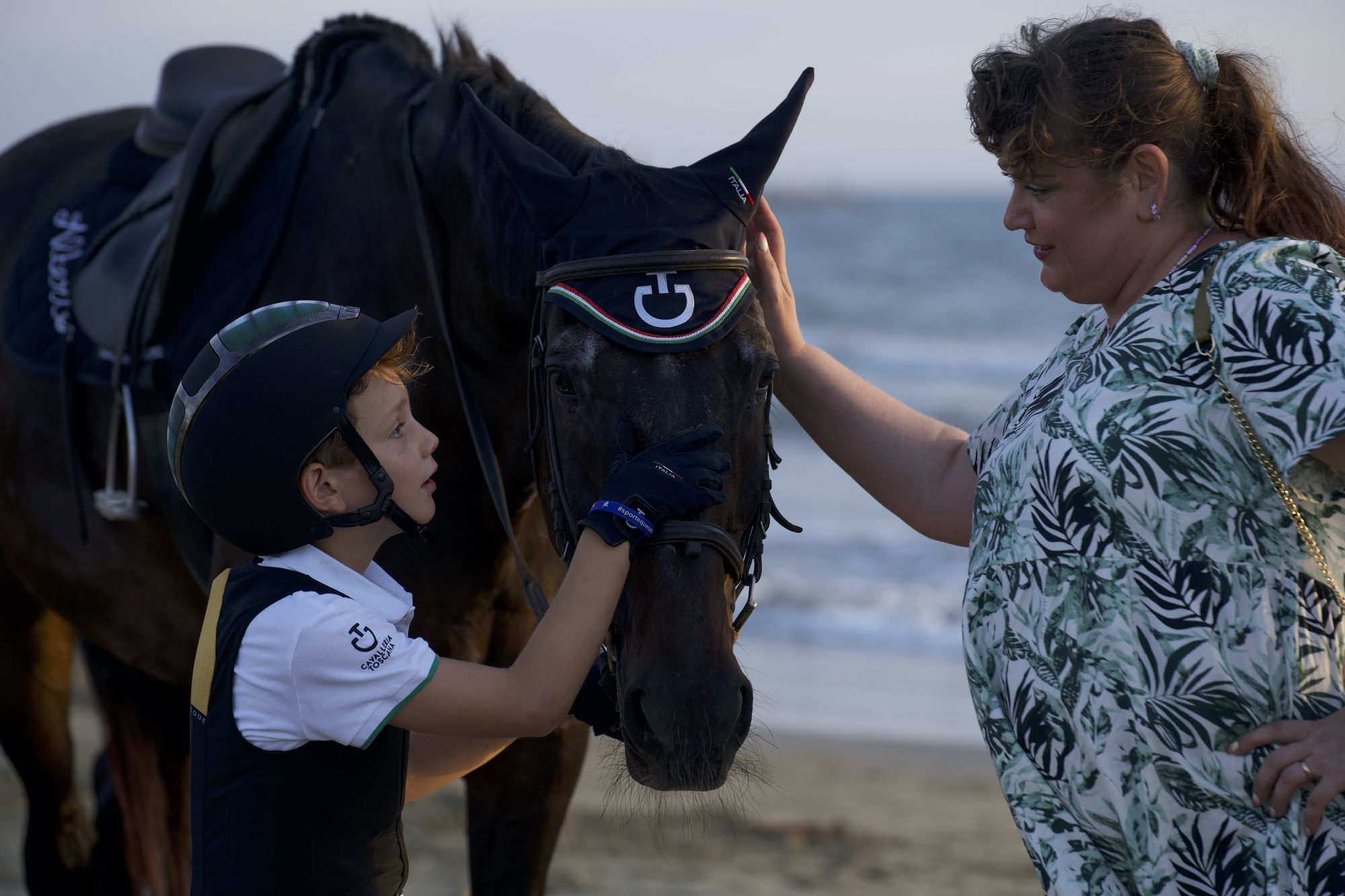 Woman and boy with a horse on the beach Woman and boy with a horse on the beach