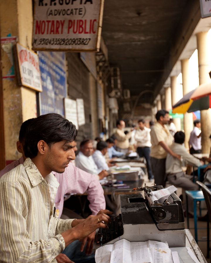 There are still a large number of court typists in India, who sit outside legal offices and type up case notes on their typewriters (Credit: Alamy)