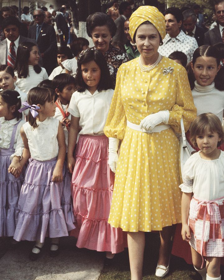 In a yellow polkadot dress by Hardy Amies with matching turban, Her Majesty leaned into the decade's flamboyant style on a 1975 visit to Mexico (Credit: Getty Images)