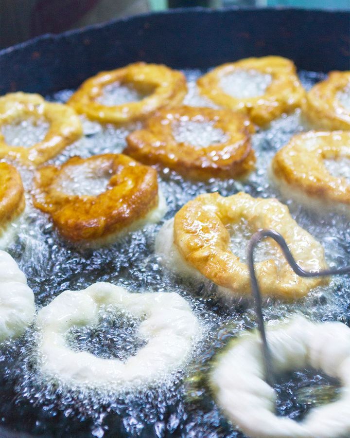 Dough is formed into a ring and dipped in frying oil for about a minute each side (Credit: Chris Griffiths/Getty Images)