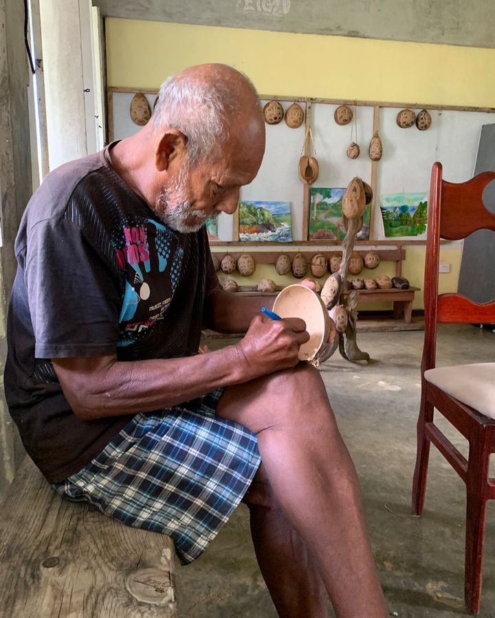 Faustulus Frederick works on a Calabash carving in the shelter he has called home since Hurricane Maria in 2017 (Credit: Jose Alison Kentish)