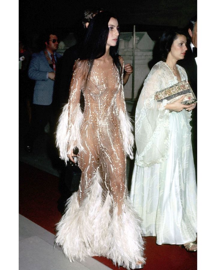 In 1974, Cher wore a stunning, feathered, see-through dress by Bob Mackie to the Met, causing a "hullabaloo", as the designer put it (Credit: Getty Images)