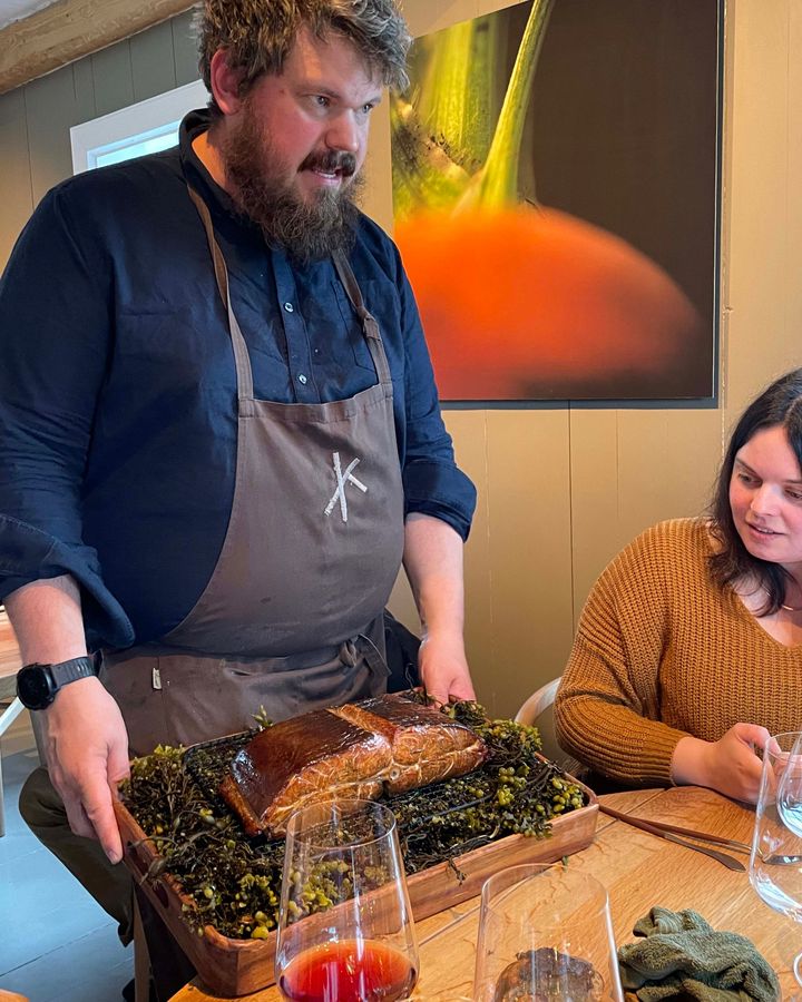 Halvar Ellingsen presents wood-smoked halibut at the table (Credit: Molly Harris)