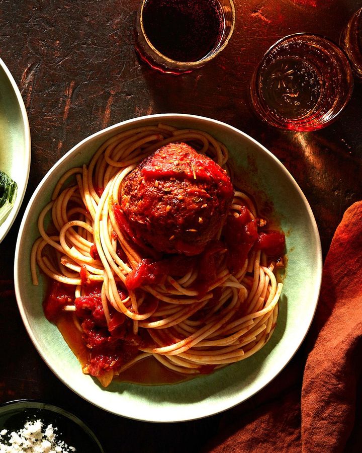 This Shanghainese-style meatball sits on top of a plate of tomato-sauced spaghetti (Credit: Johnny Miller)