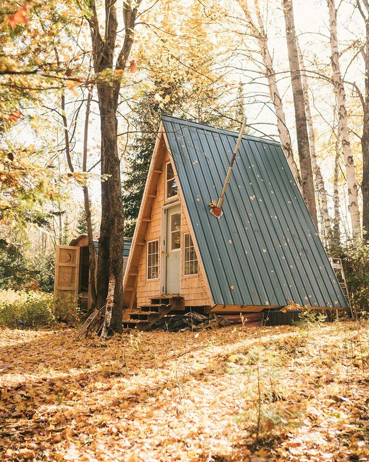 Made using reclaimed doors and windows, the small footprint of this A-frame in the woods of Quebec encourages outdoor living (Credit: Andrew Szeto)