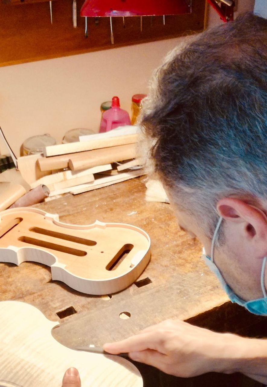Patrick Orippi working on the back of a violin; he normally makes six or seven instruments a year (Credit: Michela Vado)