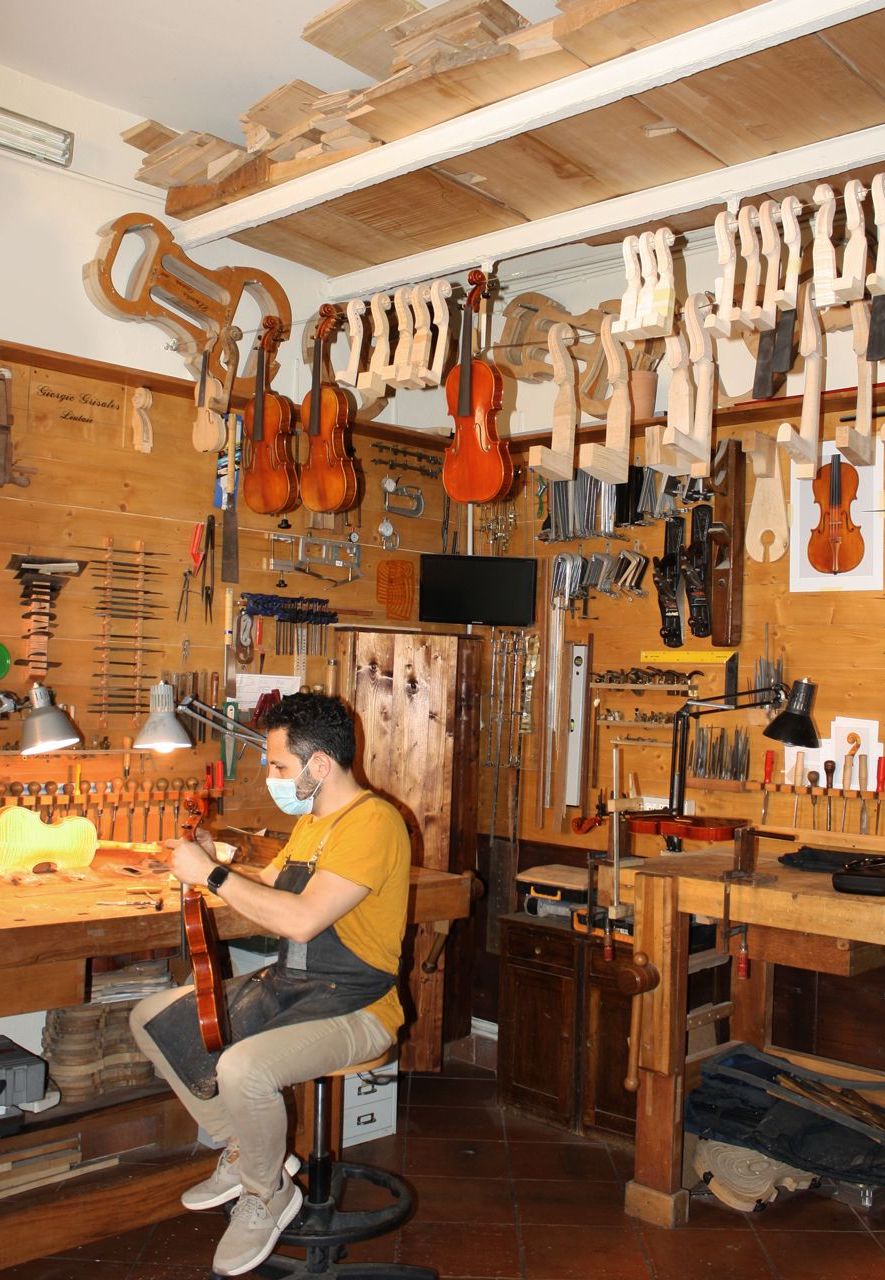 One of three young craftsmen at work in the bottega of Giorgio Grisales, the president of the city's 'Antonio Stradivari' Consortium of violin makers (Credit: Michela Vado)