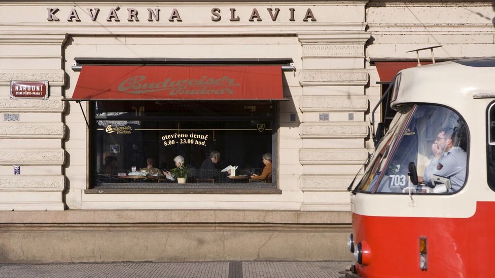 Tram passing Prague's Art Deco Kavarna Slavia cafe. (Gavin Gough/LPI)