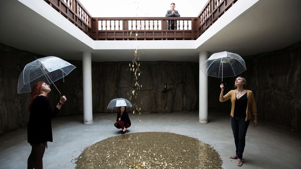 In the Russian pavilion, a shower of coins rains on female visitors in an installation by Vadim Zakharov. (Daniel Zakharov) In the Russian pavilion, a shower of coins rains on female visitors in an installation by Vadim Zakharov. (Daniel Zakharov)
