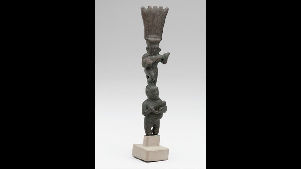 In this small statue from New York's Brooklyn Museum, Bes plays the lute while standing on the head of the goddess Bast. (Corbis)