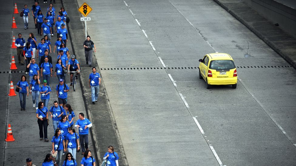 People walking on road in Medellin, Colombia (AFP)