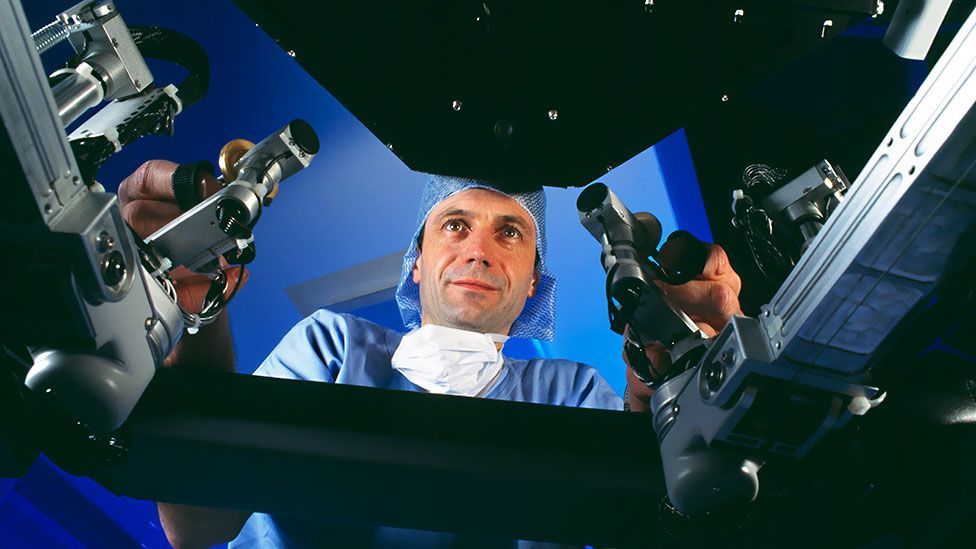 A surgeon controls the Da Vinci robot surgeon, viewing a 3D image of the body (SPL) A surgeon controls the Da Vinci robot surgeon, viewing a 3D image of the body (SPL)