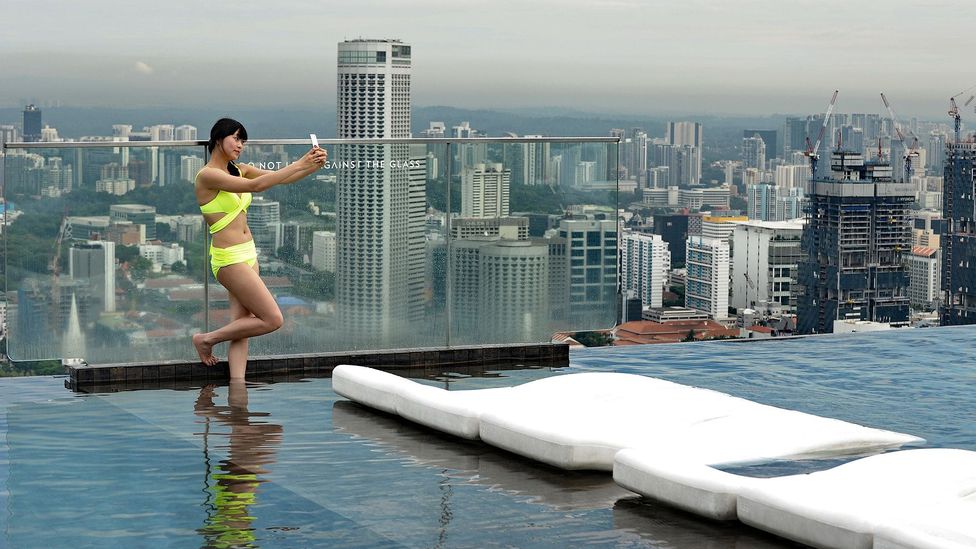 A visitor snaps a selfie with Singapore's skyline from the Marina Bay Sands resort rooftop pool. (Roslan Rahman/AFP/Getty)