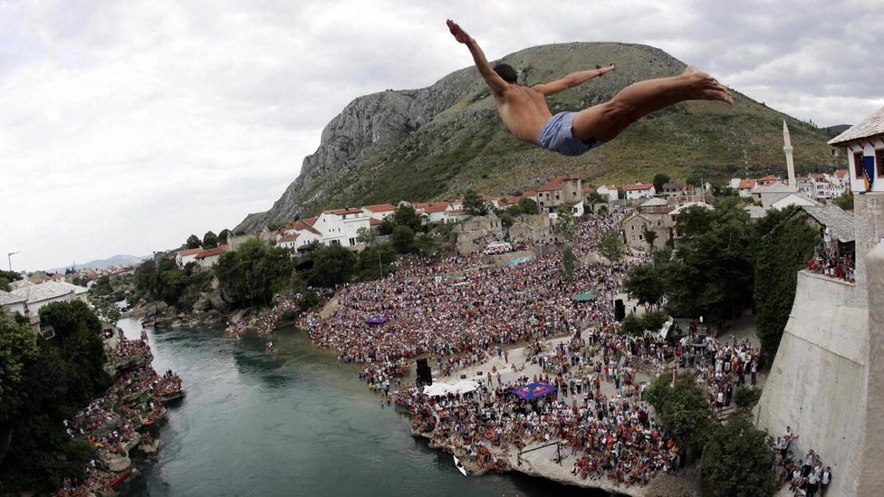 A diver tests his bravery by diving off Bosnia’s Stari Most into the icy waters of the Neretva River below. (Getty)