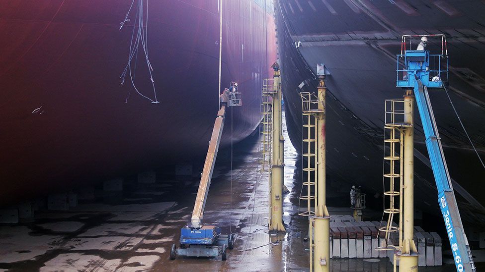 Welders connect massive steel sections of a container ship in the Shanghai Shipyard dry dock (Liam Young/Unknown Fields) Welders connect massive steel sections of a container ship in the Shanghai Shipyard dry dock (Liam Young/Unknown Fields)