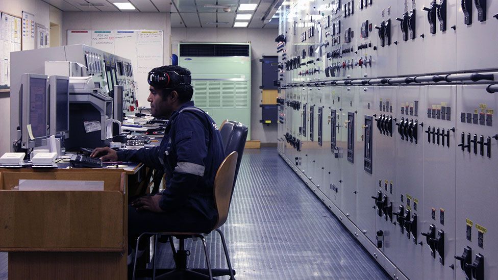 An engineer aboard the Maersk Seletar monitors engine temperature from the control room (Liam Young/Unknown Fields) An engineer aboard the Maersk Seletar monitors engine temperature from the control room (Liam Young/Unknown Fields)