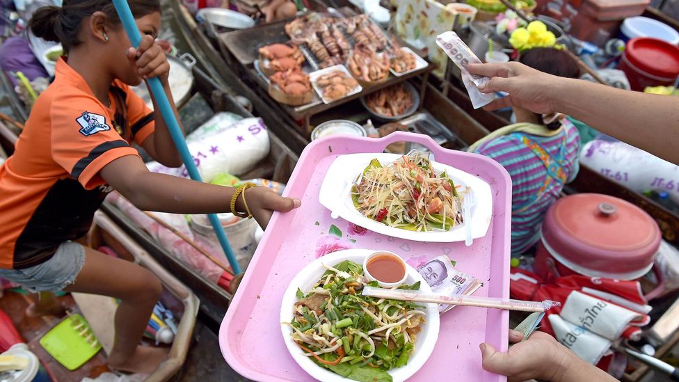 Thai food vendors serve dishes along a canal in Amphawa, west of Bangkok (Credit: Getty)