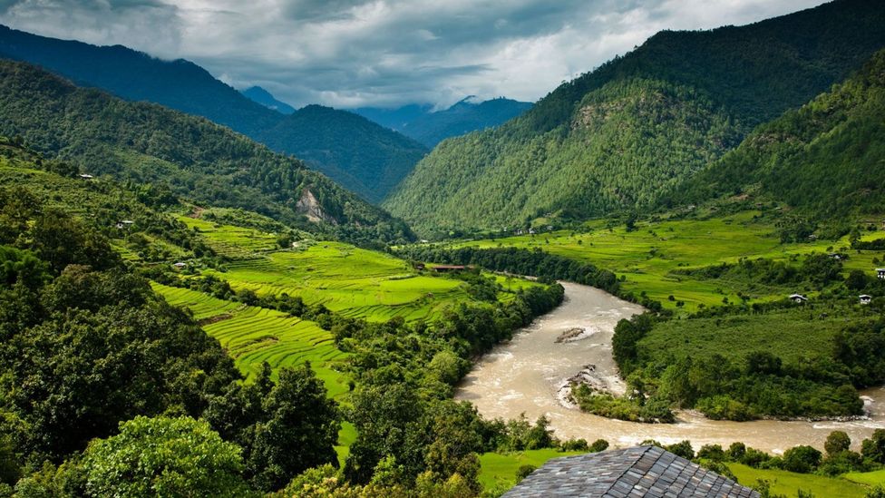 A river snakes its way through Bhutan's lush fields (Credit: Como Hotels and Resorts)