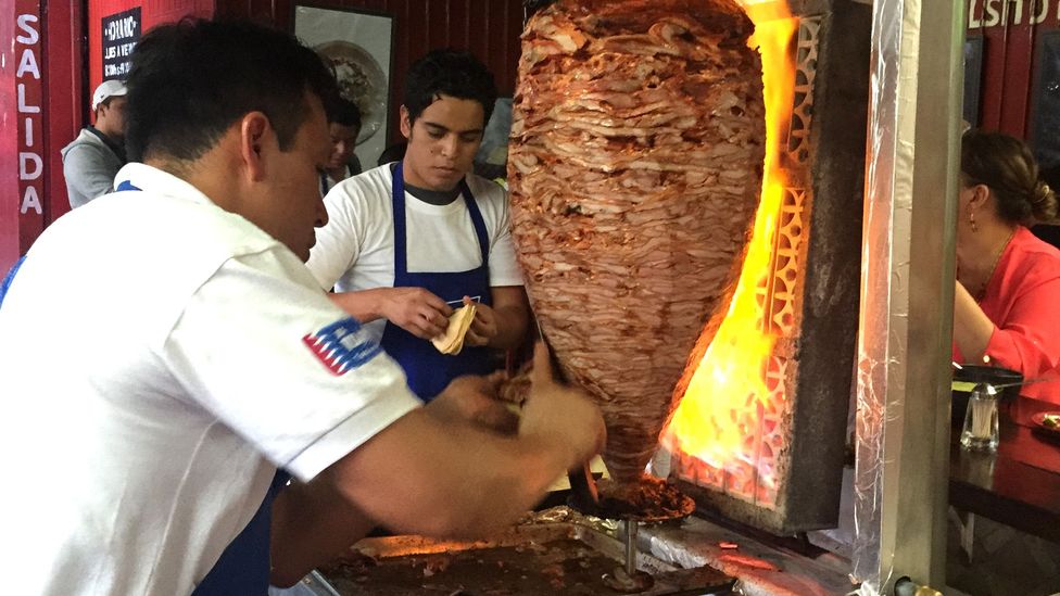 The taquero shaves off a juicy piece of pork from the trombo (Credit: David Farley) The taquero shaves off a juicy piece of pork from the trombo (Credit: David Farley)