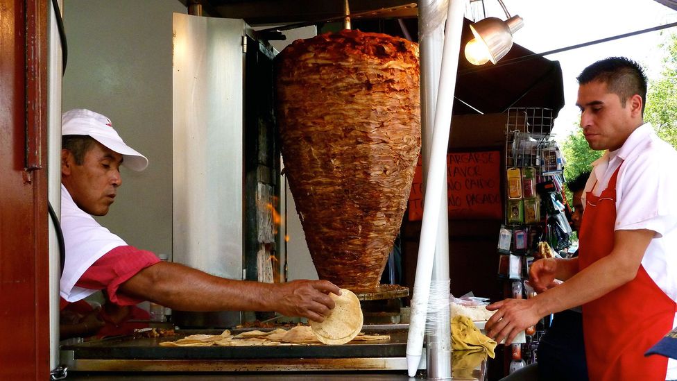 The pork is placed inside a corn tortilla after it’s carved off (Credit: CarlosVanVegas/Mexico City – Streetfood/Flickr/CC BY 2.0) The pork is placed inside a corn tortilla after it’s carved off (Credit: CarlosVanVegas/Mexico City – Streetfood/Flickr/CC BY 2.0)