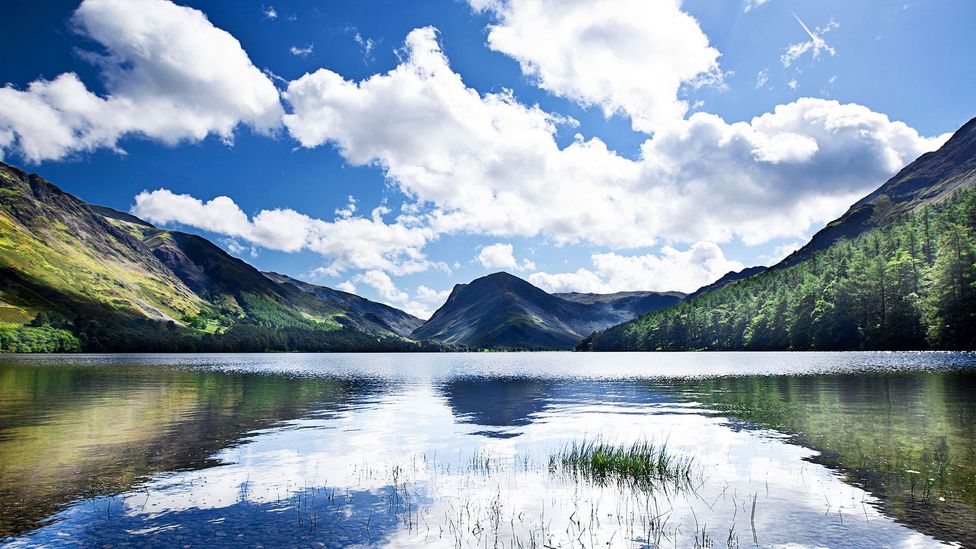 Bright skies reflect off of Buttermere Lake in Cumbria (Credit: JPagetRMphotos/Alamy)
