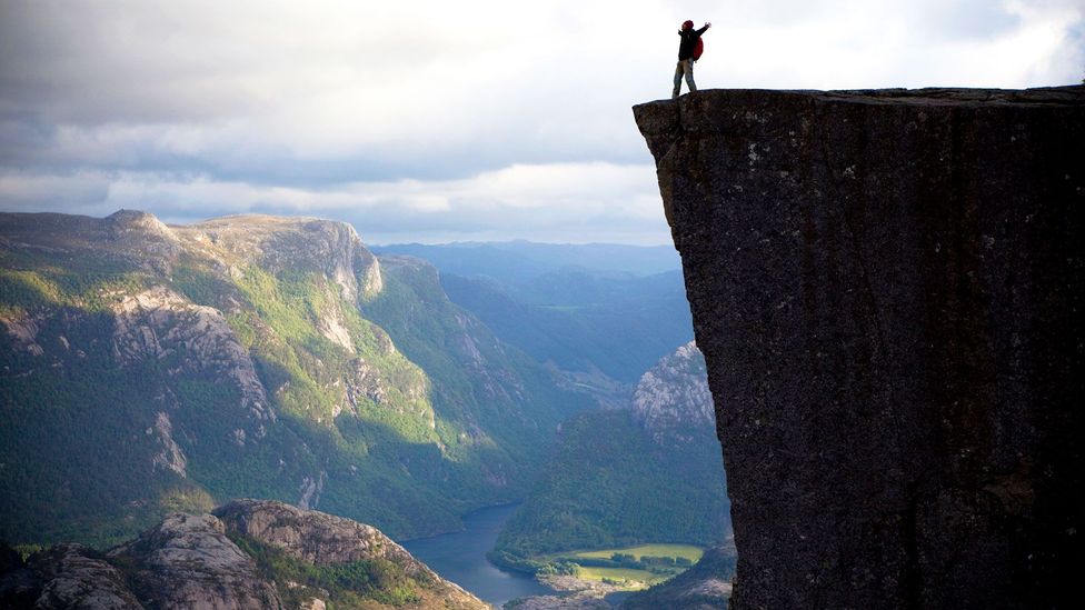 A hiker revels on top of Preikestolen in Norway (Credit: Anton Sokolov/iStock)