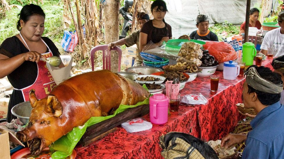 People feast on babi guling after it’s been cooked for around two hours (Credit: age fotostock/Alamy)