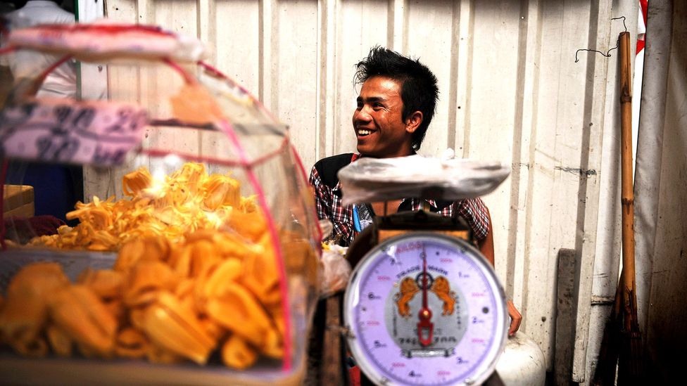A Thai vendor finds delight in his work day (Credit: Christophe Archambault/Getty)