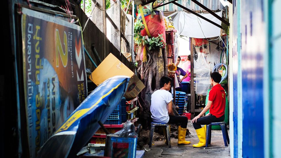 Market workers take a social break in a Bangkok alley (Credit: Glenn Sundeen/Getty)