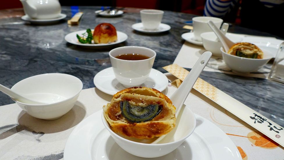 Underneath the flaky crust, the black and green century egg is revealed (Credit: Kate Springer)