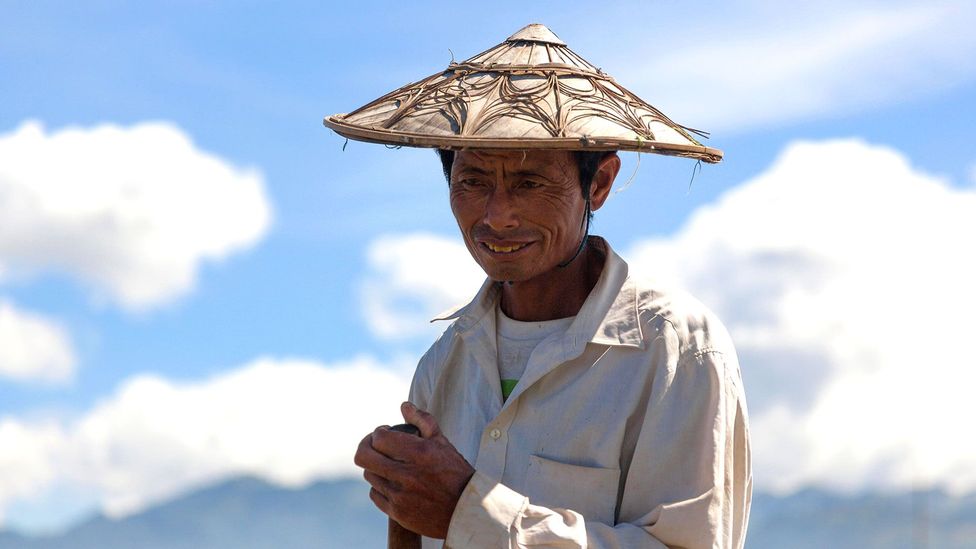 A fisherman shields the sun with a traditional kha-mauk hat (Credit: Matthew Kyte/Alamy)