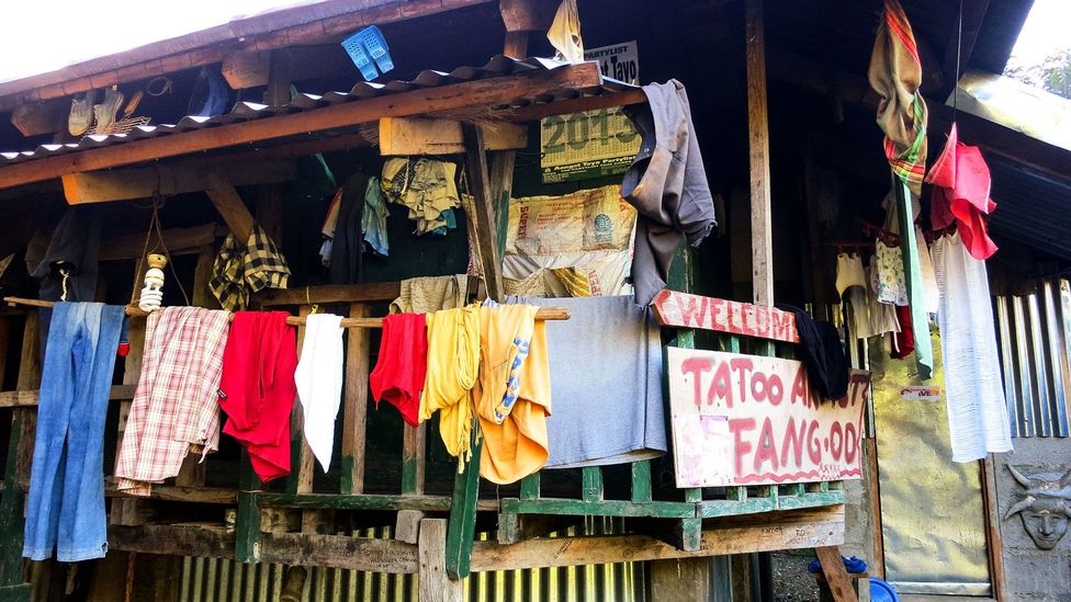 A simple sign marks Whang Od's house for visitors (Credit: HoneyTrek) A simple sign marks Whang Od's house for visitors (Credit: HoneyTrek)