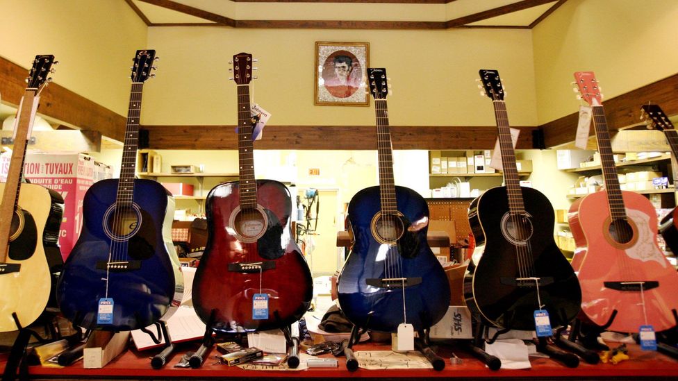 A portrait of Elvis Presley hangs above guitars sold at the Tupelo Hardware Store (Credit: Gary Coronado/The Palm Beach Post/Alamy)