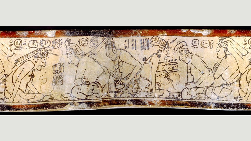 An elderly teacher corrects his pupils, with a thin line connecting the mouth to the written speech. This motif may have first appeared in 650 BC. (Credit: Justin Kerr) An elderly teacher corrects his pupils, with a thin line connecting the mouth to the written speech. This motif may have first appeared in 650 BC. (Credit: Justin Kerr)