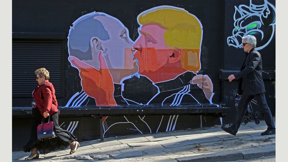 A new mural by the Lithuanian artist Mindaugas Bonanu shows Donald Trump and Vladimir Putin in a passionate embrace (Credit: Petras Malukas/AFP/Getty Images)