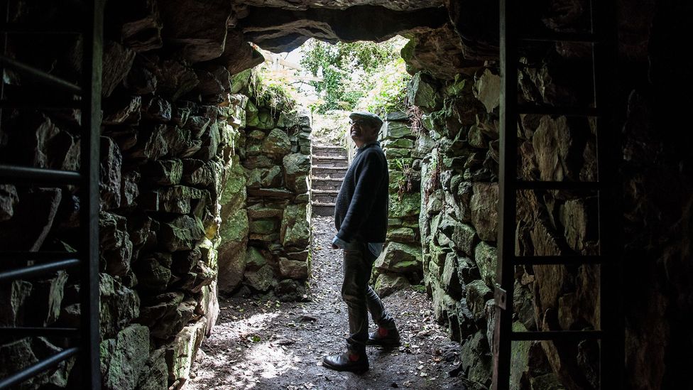 Standing in the tunnel’s entrance, archaeologist James Gossip peers back into Halliggye Fogou (Credit: Amanda Ruggeri)
